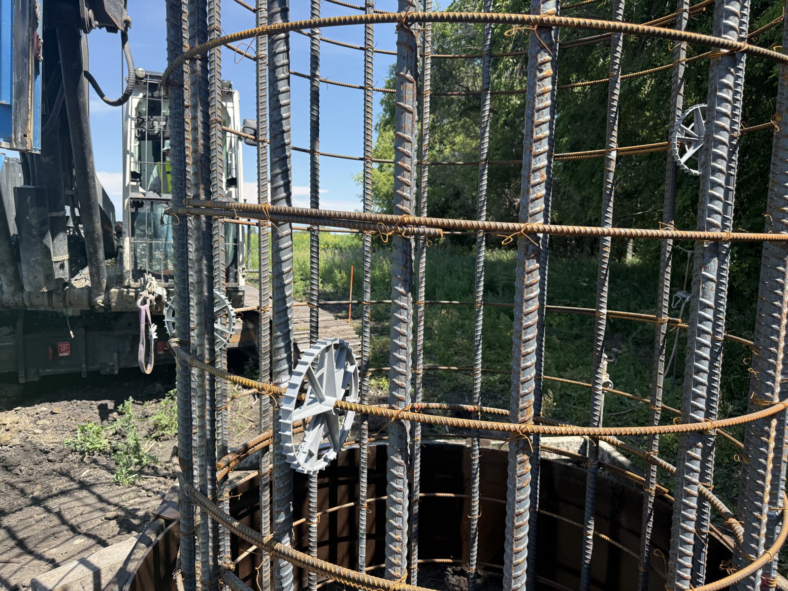 Rebar cage over a drilled shaft, drill in the background